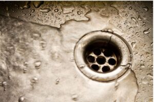 Water flows down a drain. Act now to prevent slow drains.
