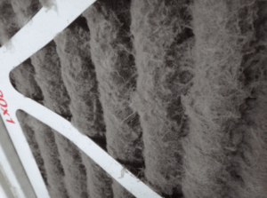 A picture of a dirty and clogged furnace filter (particularly a disposable or pleated air filter).